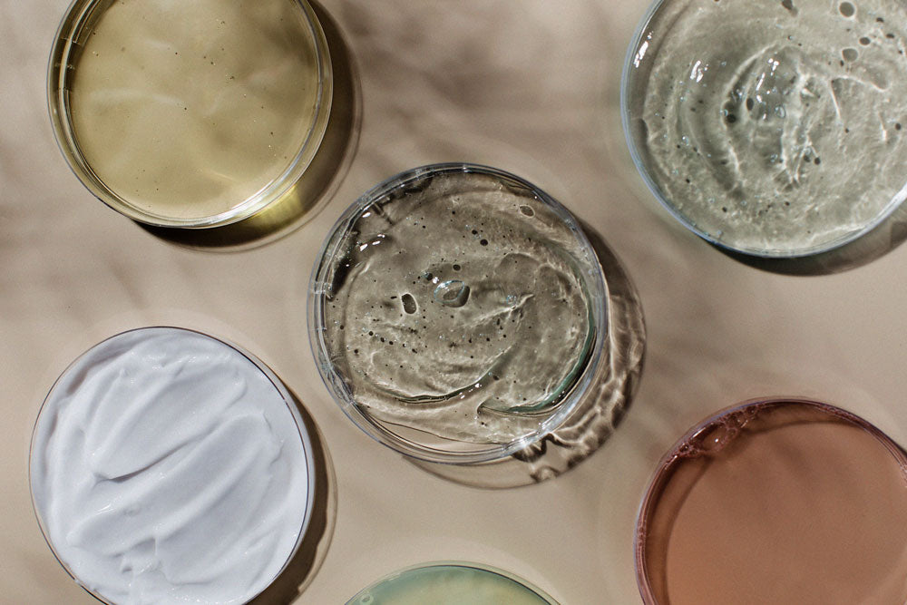 Various skincare products in petri dishes.