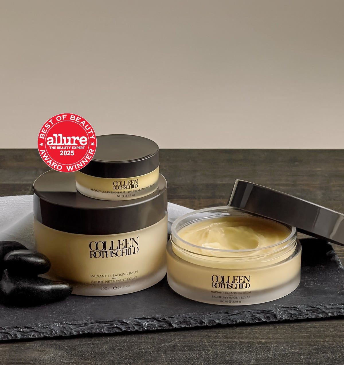 Colleen Rothschild Radiant Cleansing Balm in 3 sizes on wood surface.