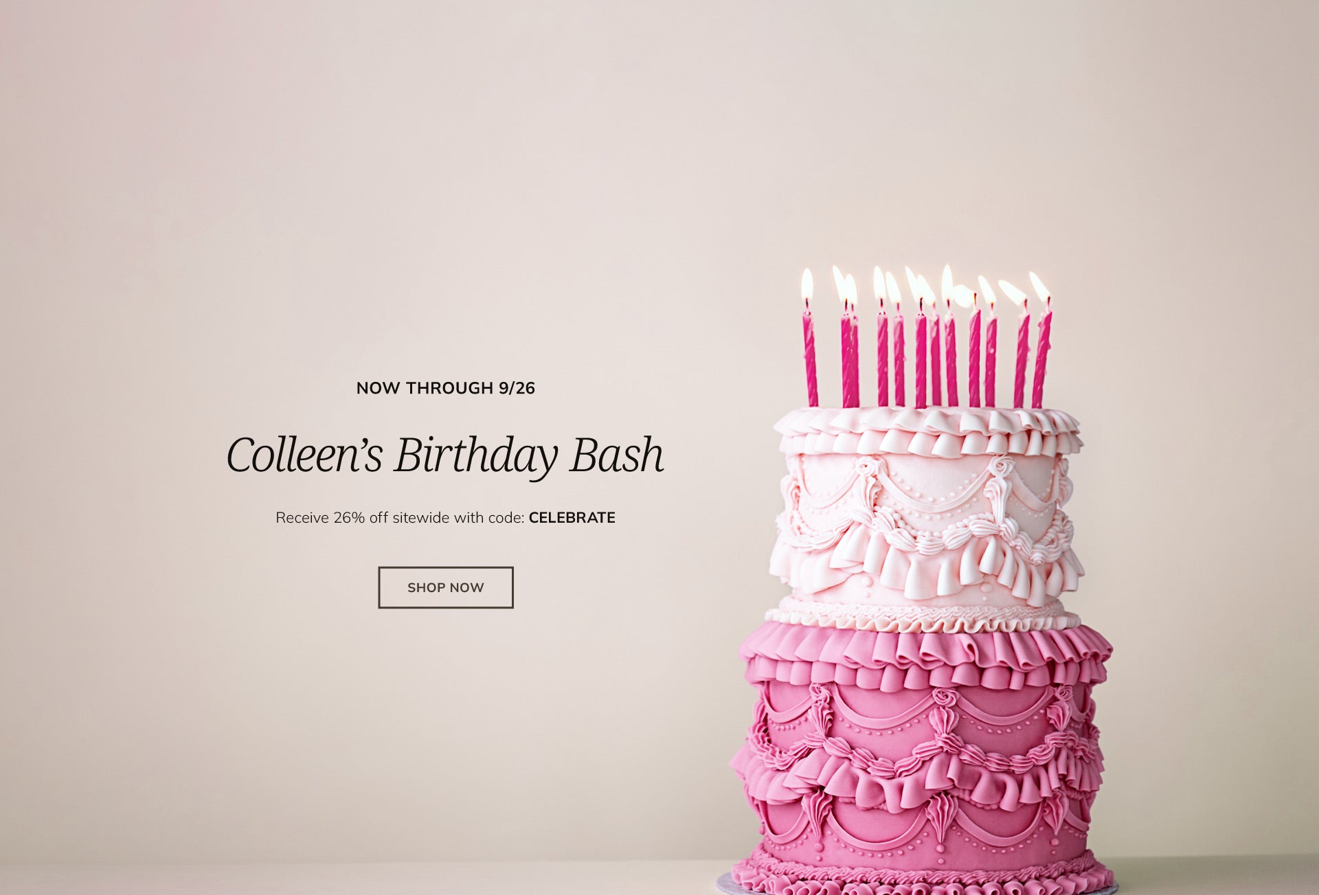 Pink tiered birthday cake with candles
