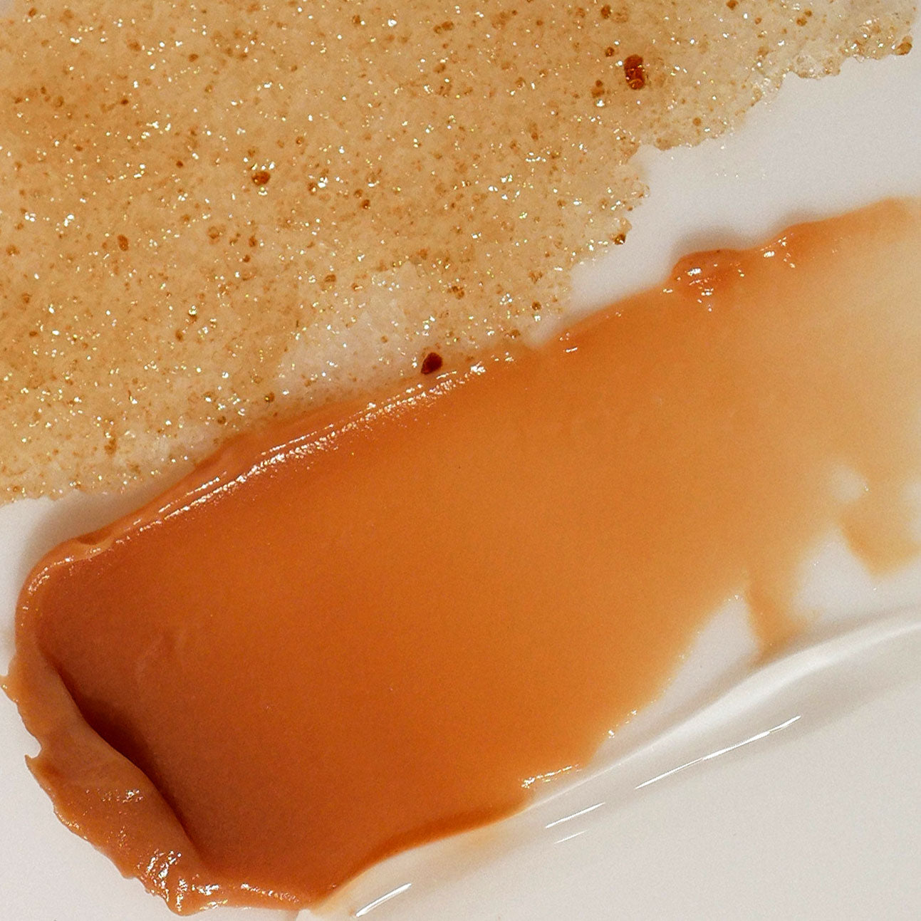 Close-up of a lip sugar scrub and smooth amber lip balm.