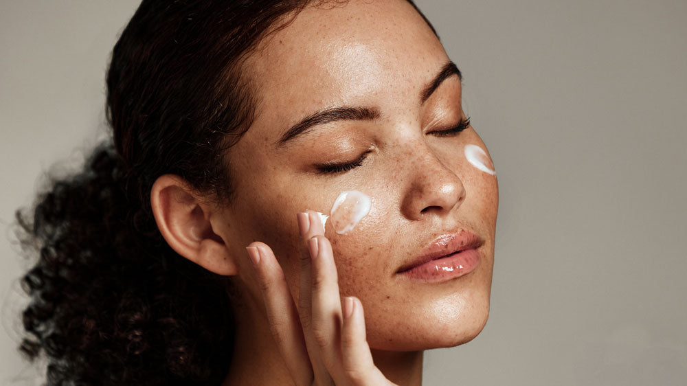 Woman applying facial cream.